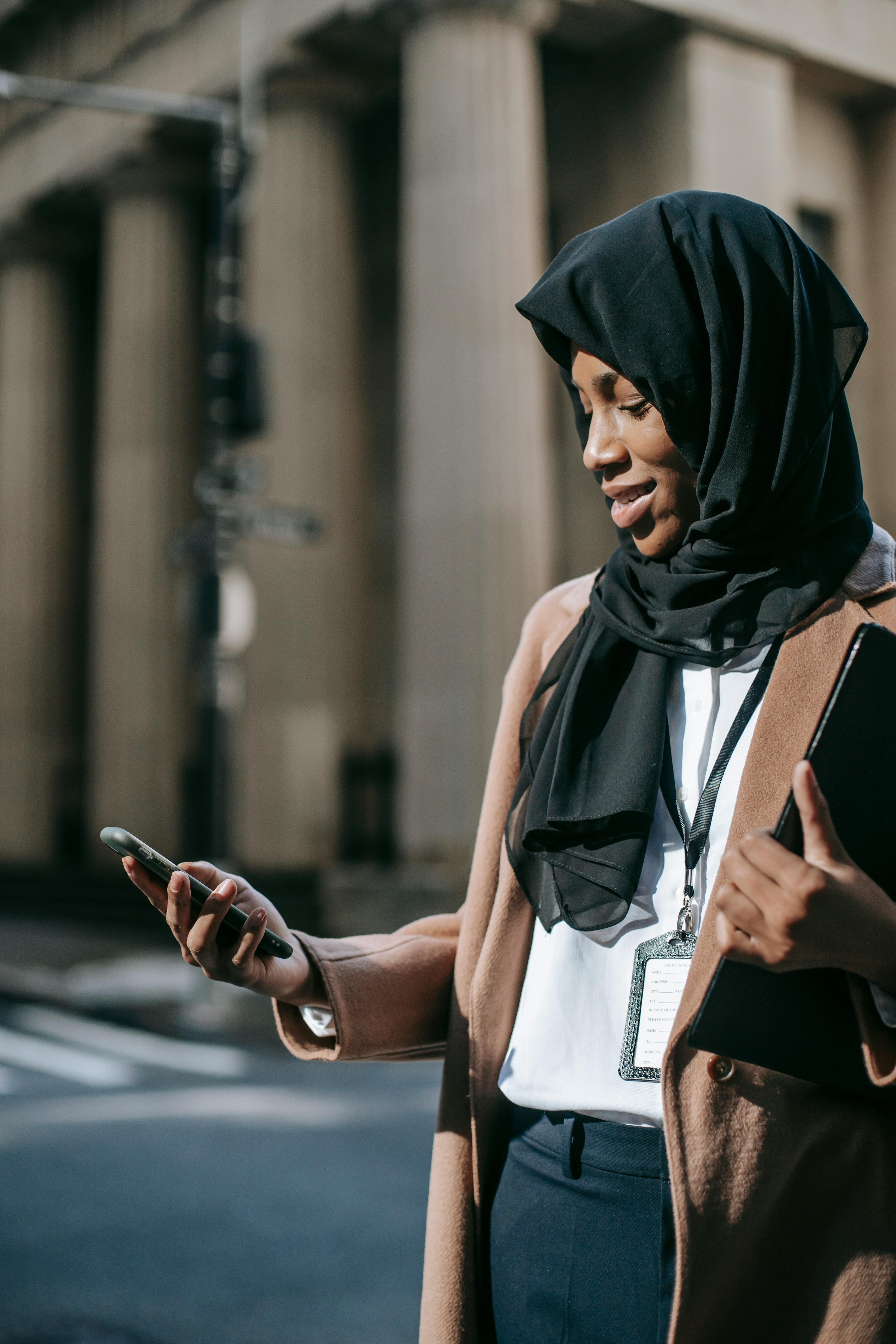 delighted woman in hijab chatting on phone