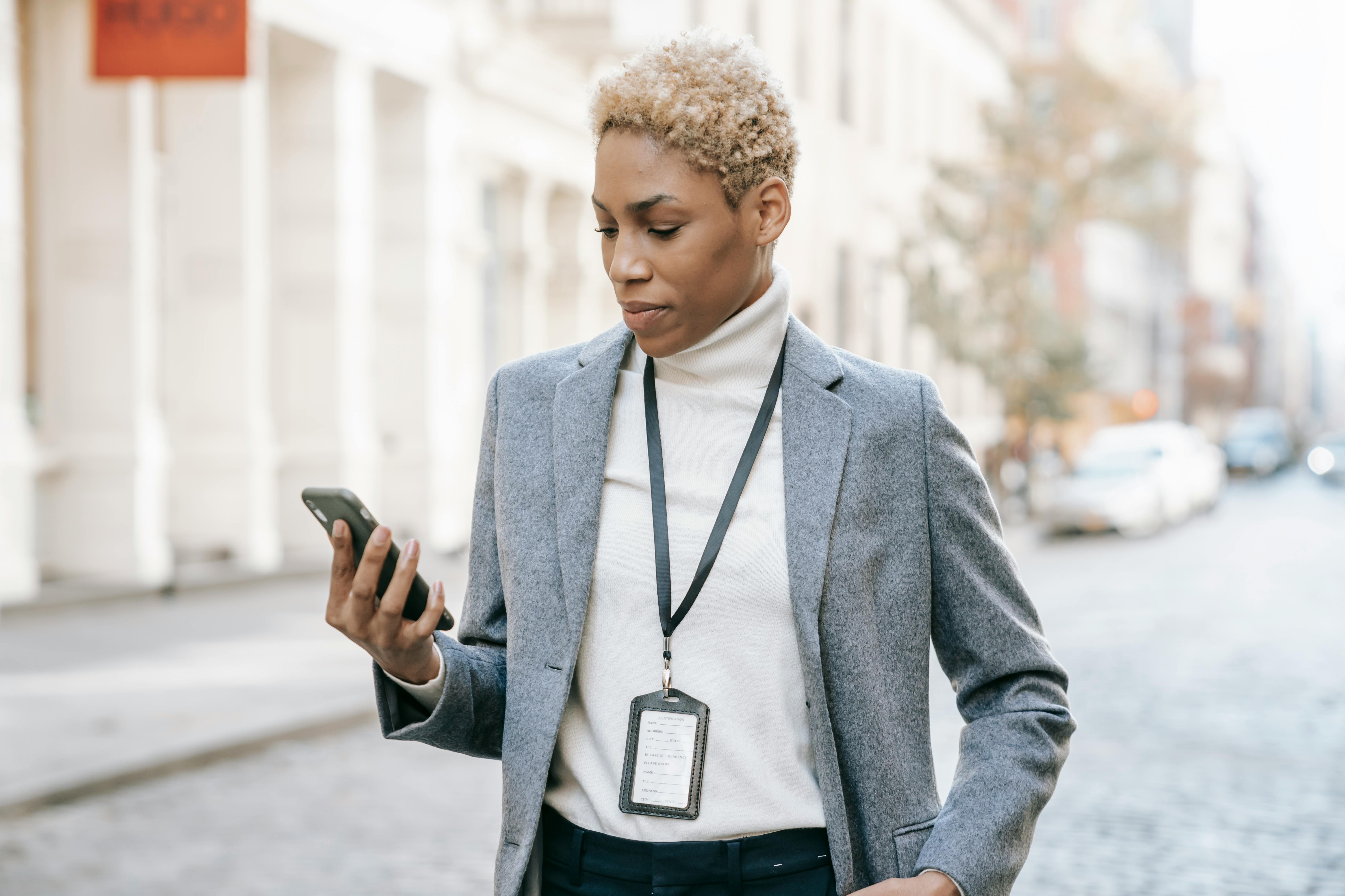 focused black manager browsing modern cellphone in city street