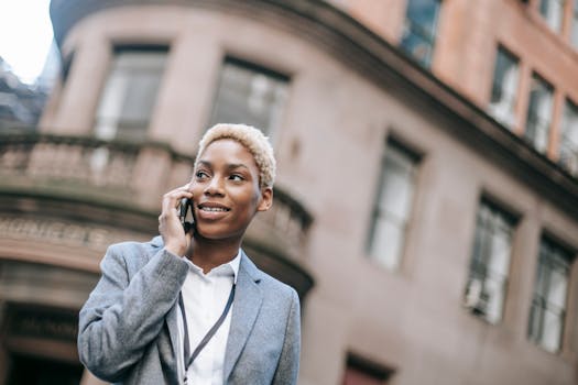 Professional woman in a city using a phone, smiling and engaging in conversation.
