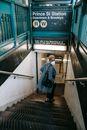 Elegant young black lady walking downstairs towards underground station