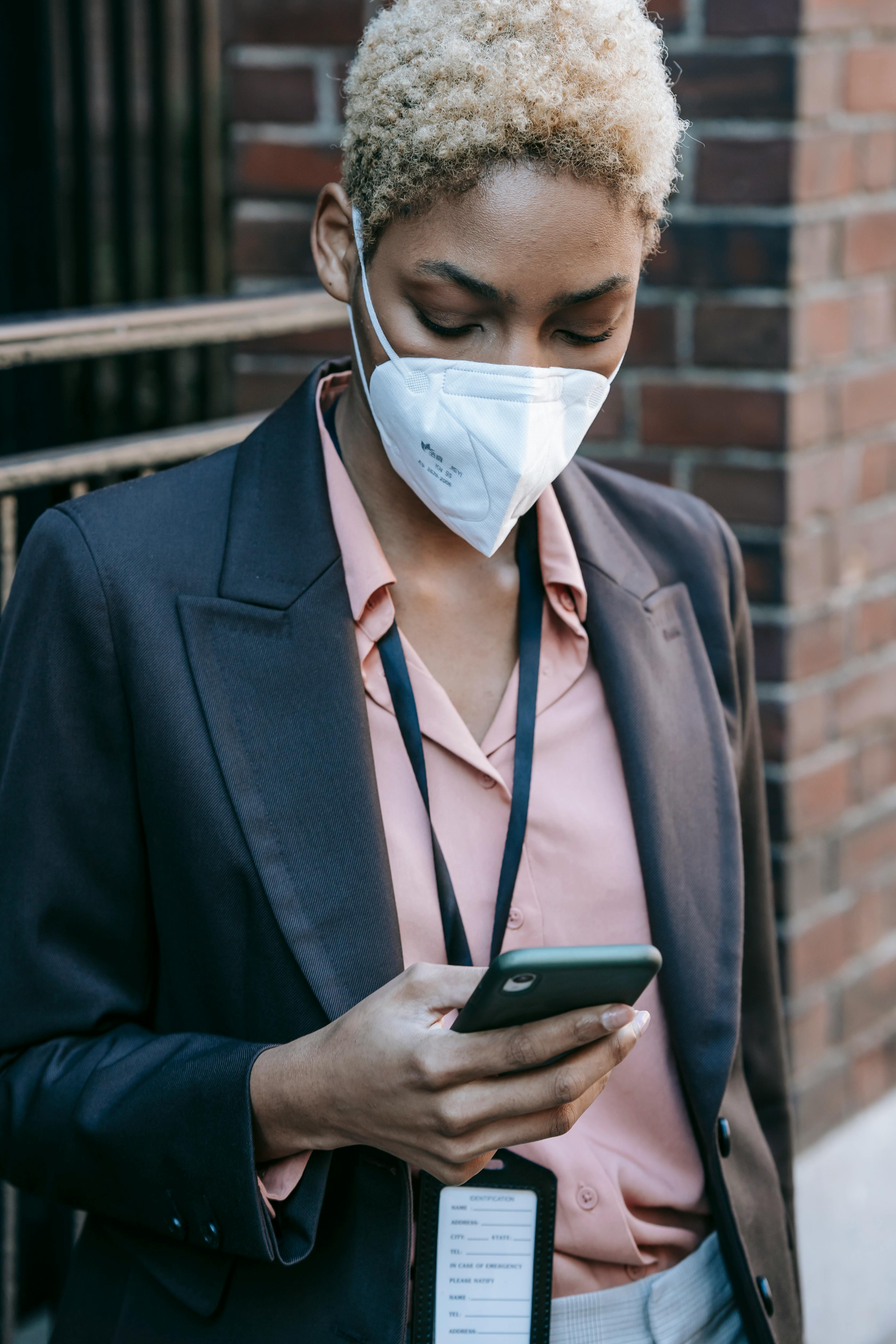 stylish black female manager using smartphone on street