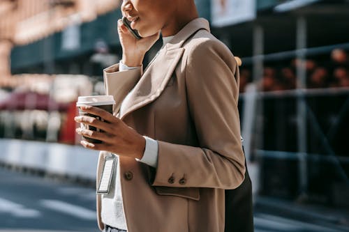 Mujer En Abrigo Marrón Con Taza Roja Y Blanca