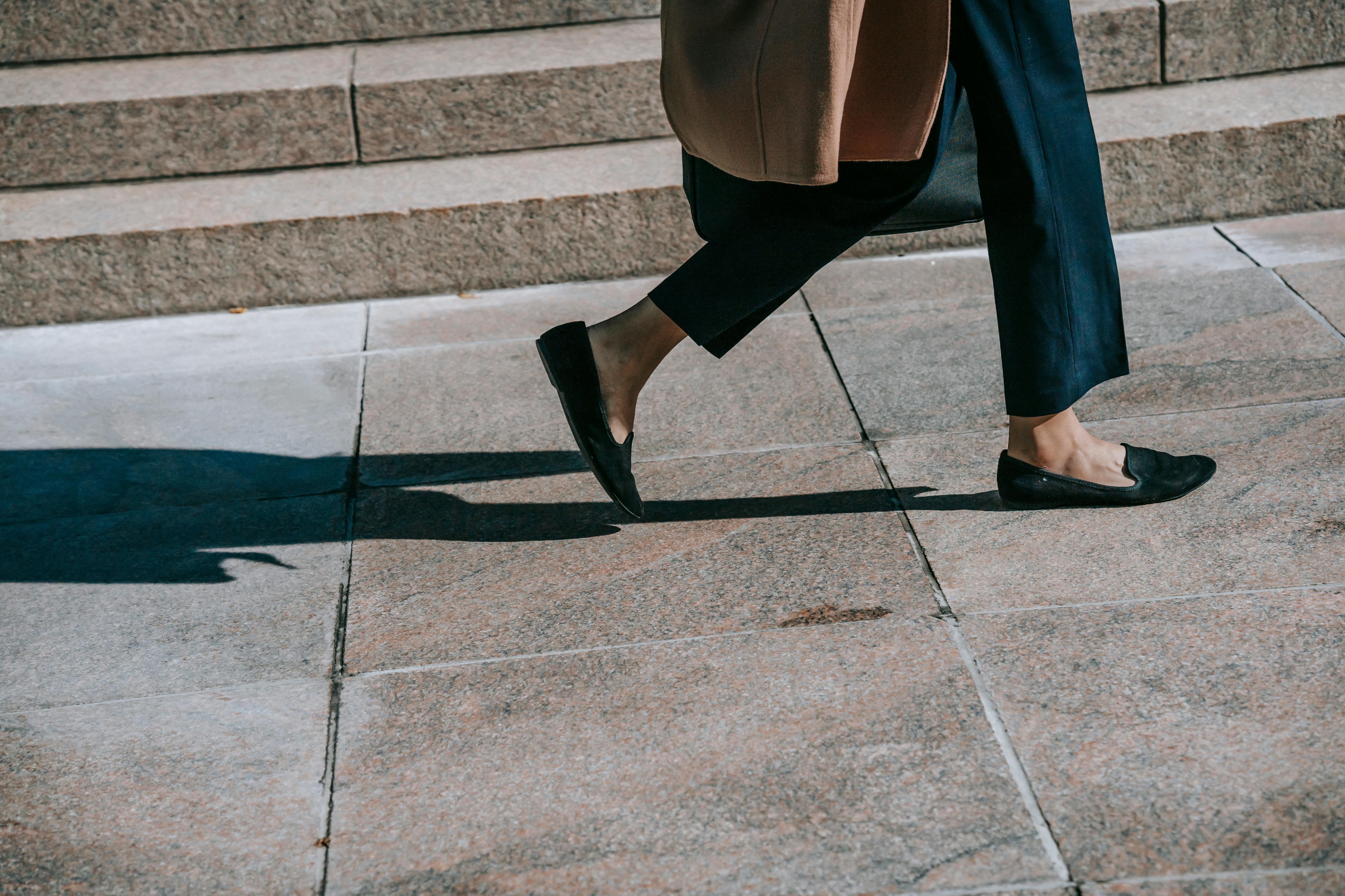 crop faceless stylish woman walking on street