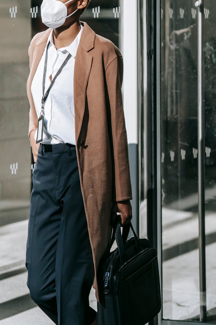 Crop Unrecognizable Black Businesswoman In Mask Leaving Modern Building