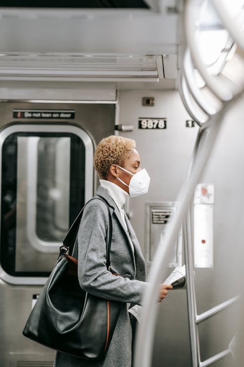 Hombre Con Mascarilla Blanca Y Chaqueta Gris En Tren