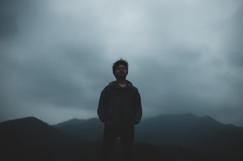 Man Standing in Fog on Mountain Background 