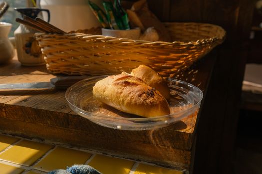 Freshly baked rustic bread on a wooden kitchen counter with warm lighting.