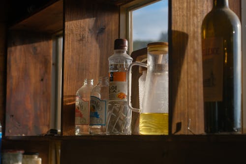 Close-up of Glass Bottles Standing on a Wooden Shelf