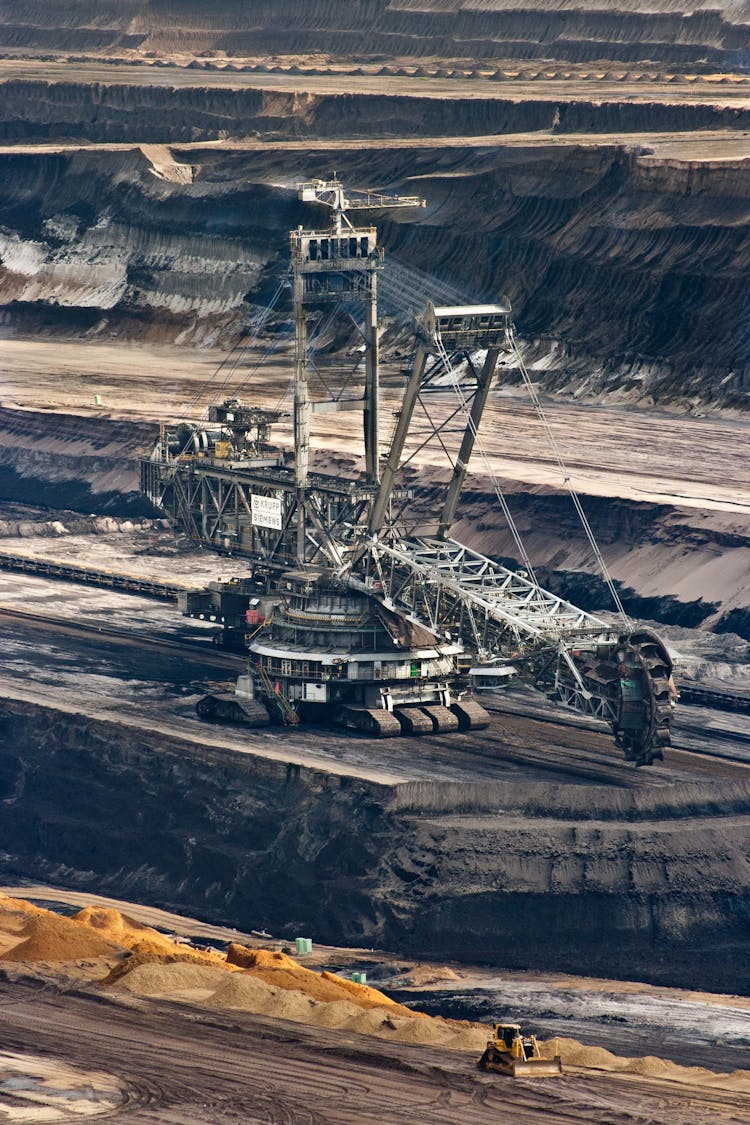 Silver Steel Mining Crane On Black Rocky Soil During Daytime