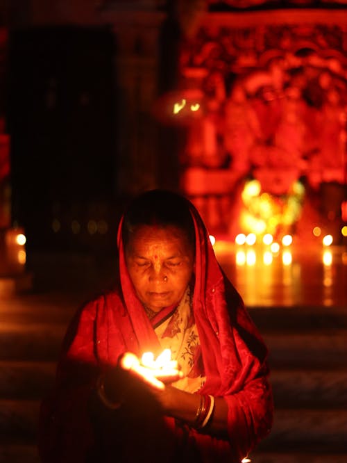Woman in a Saree Holding a Burning Candle 