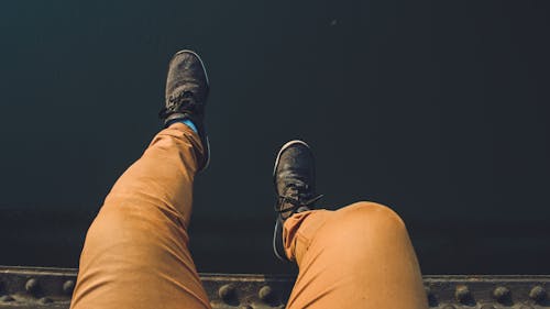 Free Person Wearing Brown Jeans With Pair of Black Sneakers Stock Photo