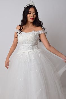 Beautiful bride posing in a glamorous white wedding dress with a tiara.