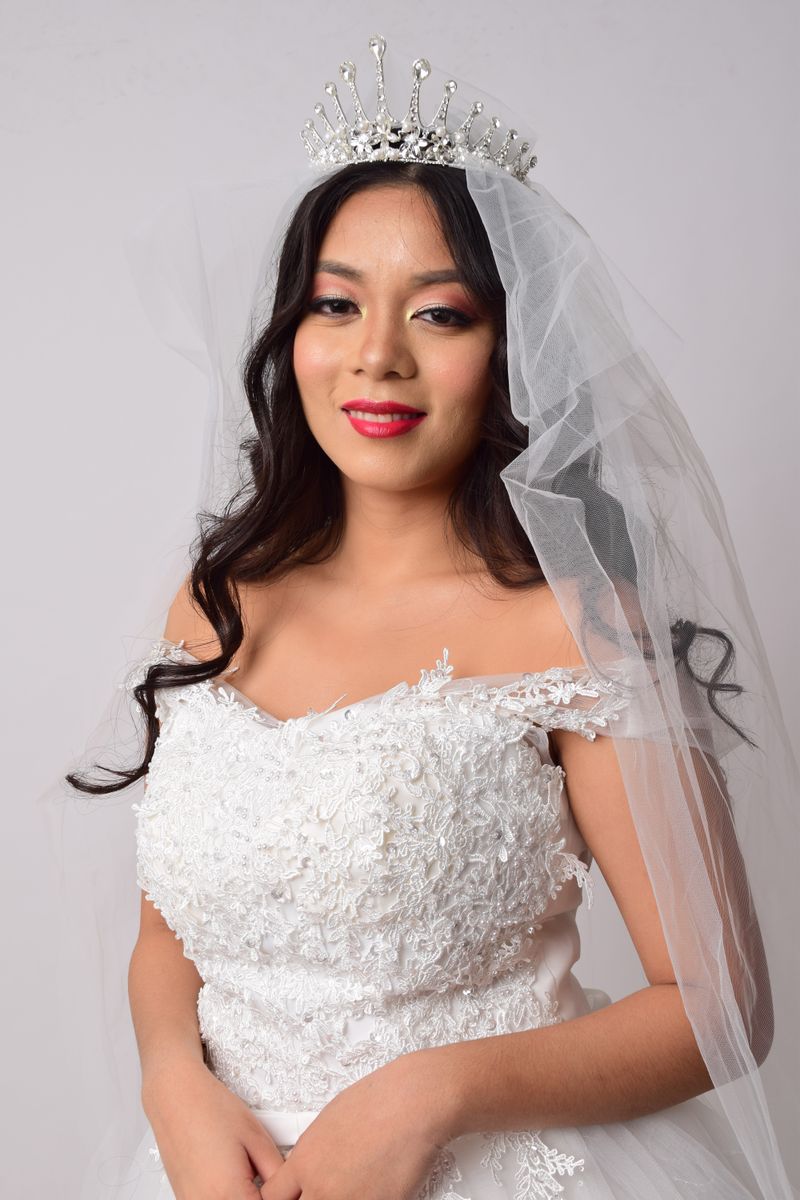 Bride wearing soft bridal makeup and a lace dress