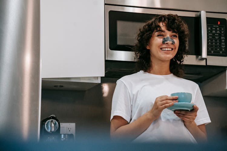 Cheerful Woman With Cleaning Nose Mask Having Coffee