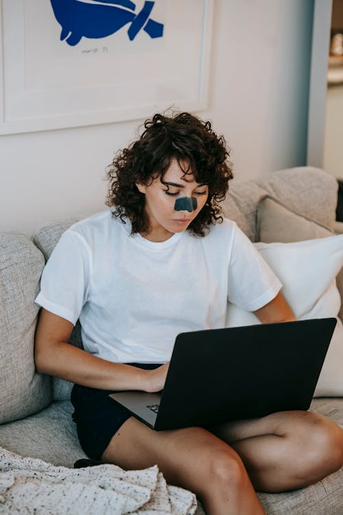 Free Busy woman watching laptop in living room Stock Photo