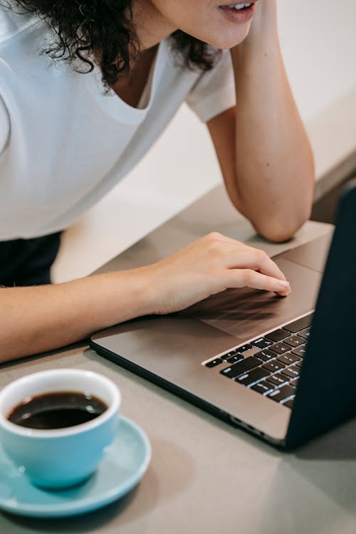 Woman working on laptop with coffee cup