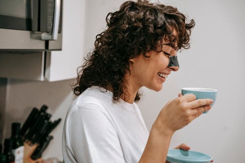 Free Smiling woman drinking coffee at home Stock Photo