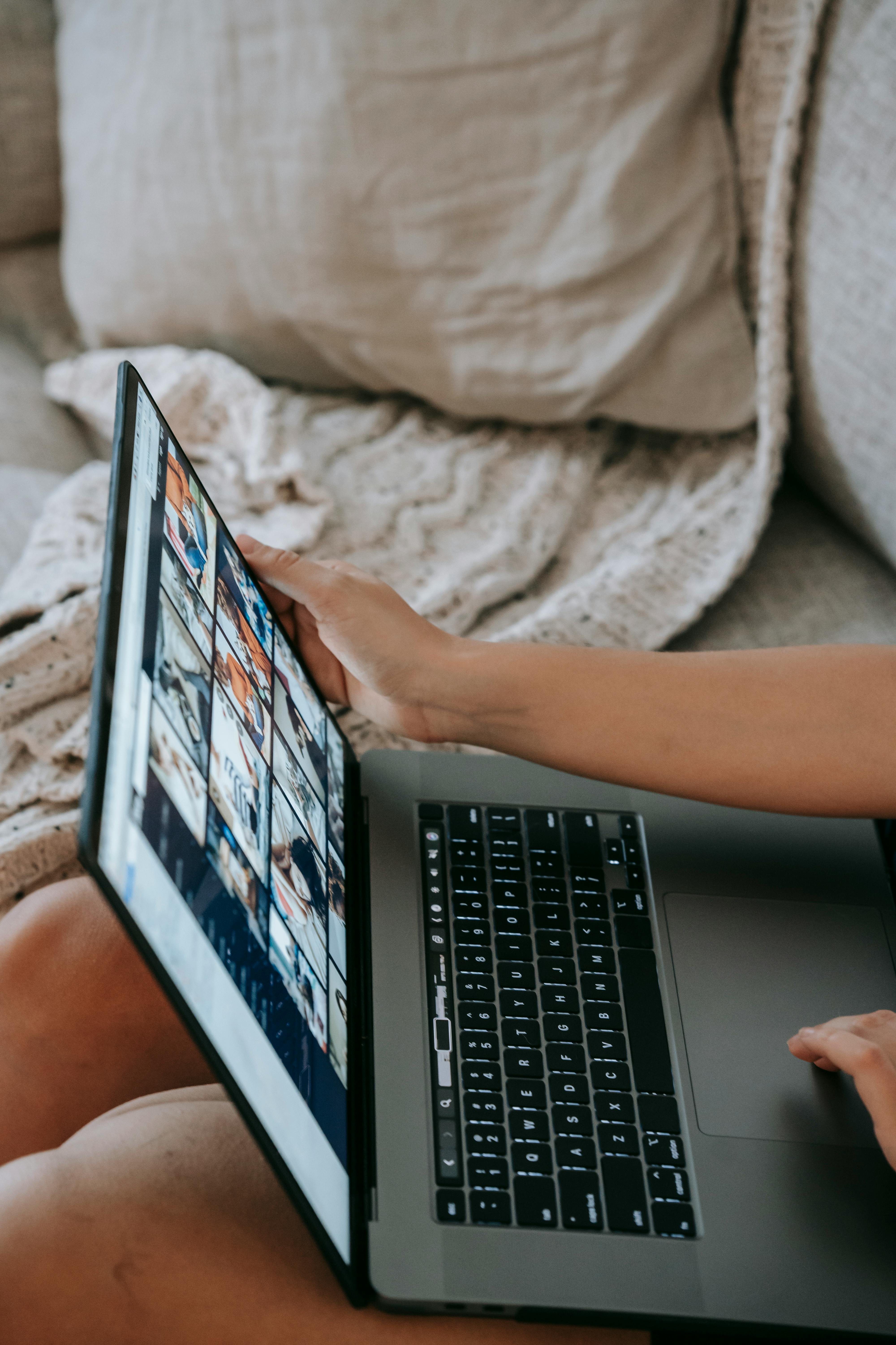 faceless woman sitting on couch and working online on laptop