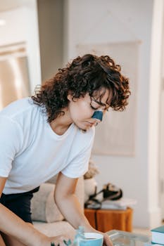 Young woman with a nose patch enjoys coffee as part of her morning skincare routine at home.