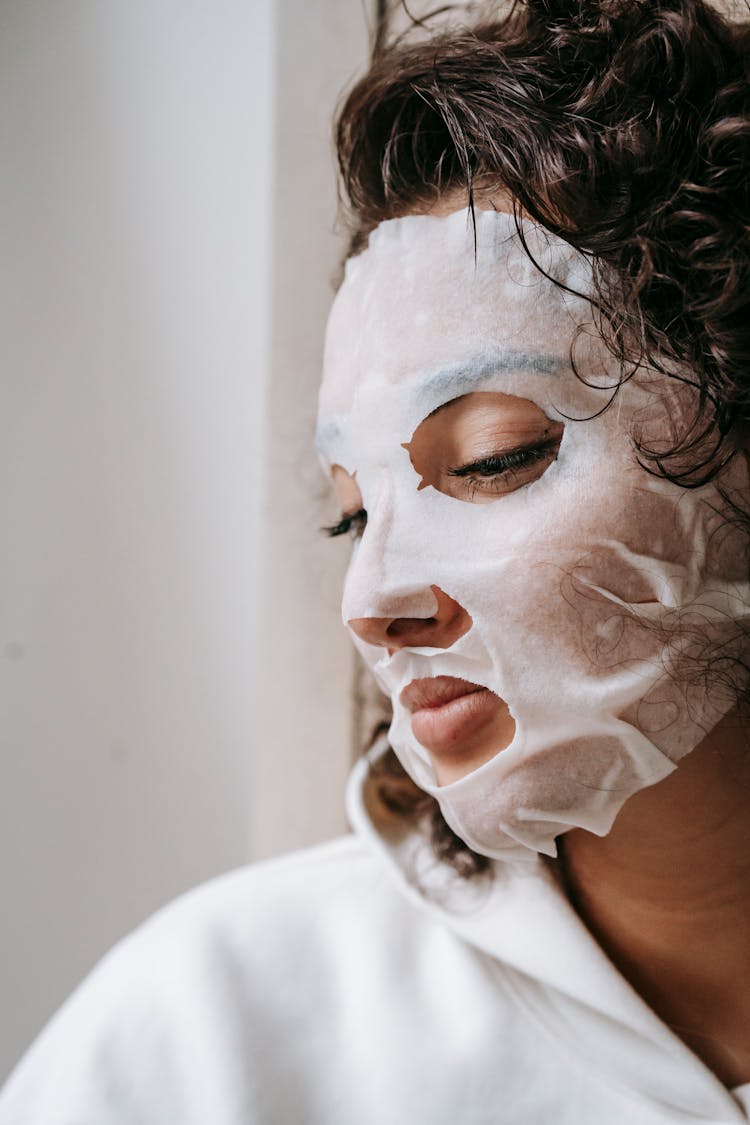 Focused Woman In Sheet Mask At Home