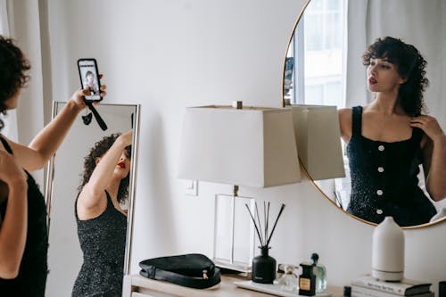 Charming woman taking selfie in room