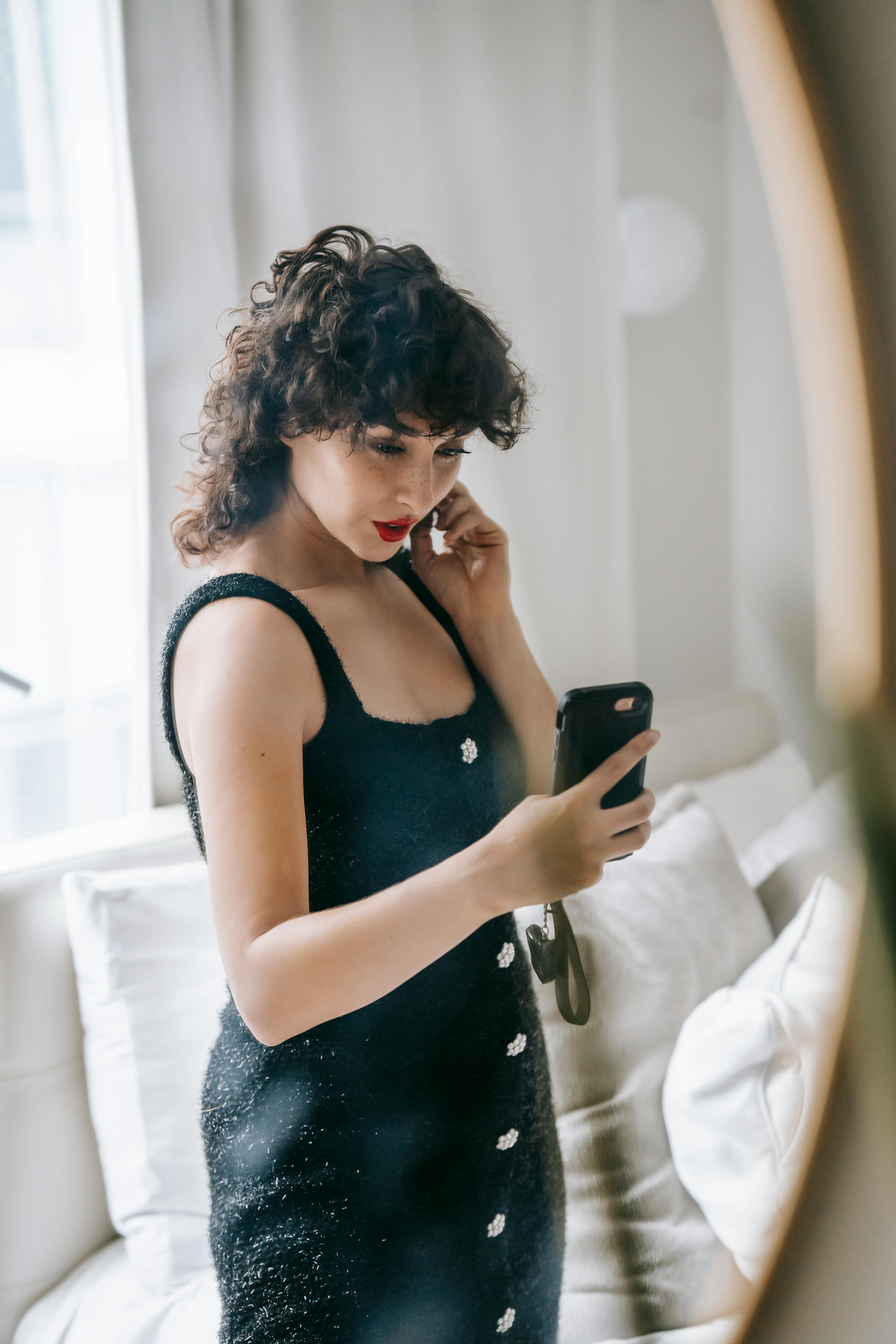 elegant woman taking selfie on smartphone in front of mirror