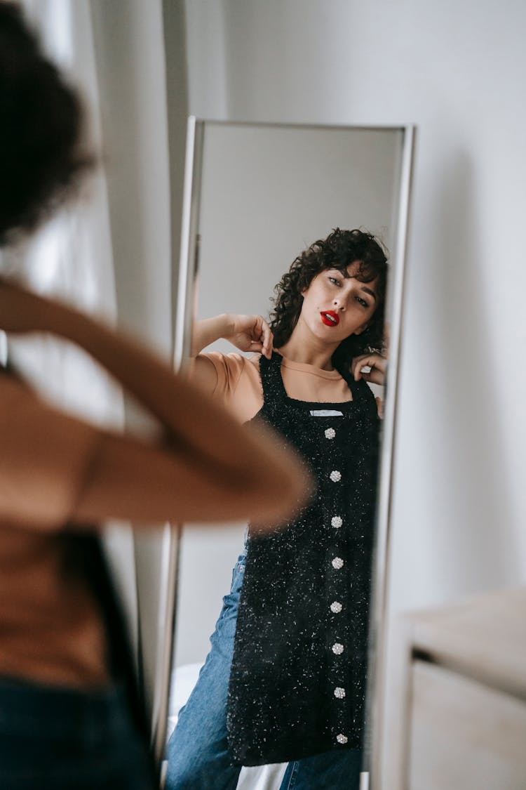 Crop Woman Trying On Dress In Front Of Mirror Indoors