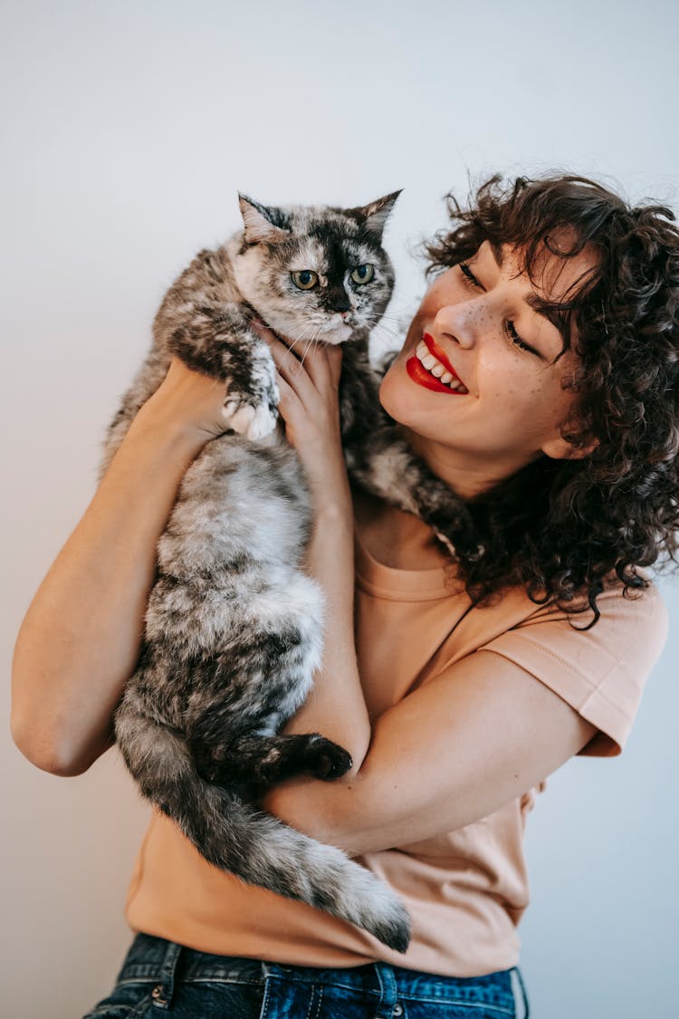 Crop Smiling Woman Embracing Cute Cat On White Background