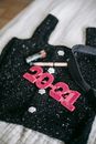 Decorative numbers on feminine apparel with beauty products on bed