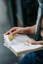 Crop woman reading book in city