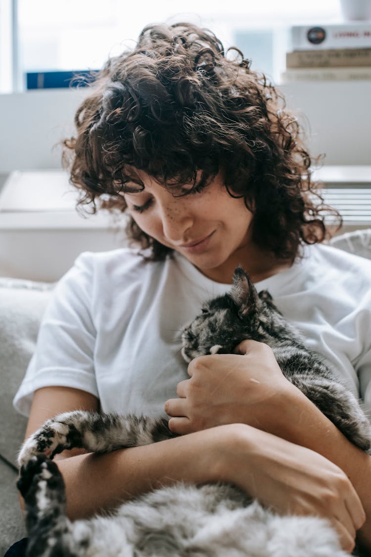 Smiling Woman Sitting On Sofa With Cat