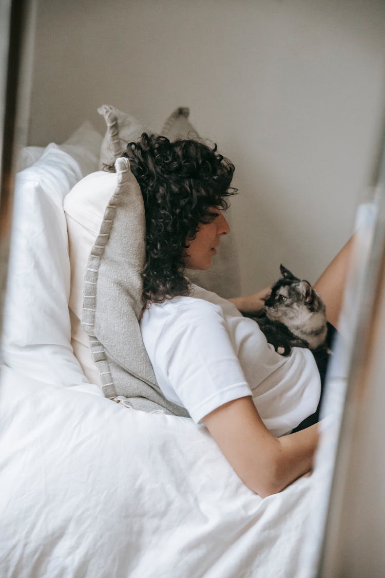 Woman With Cat Lying On Bed