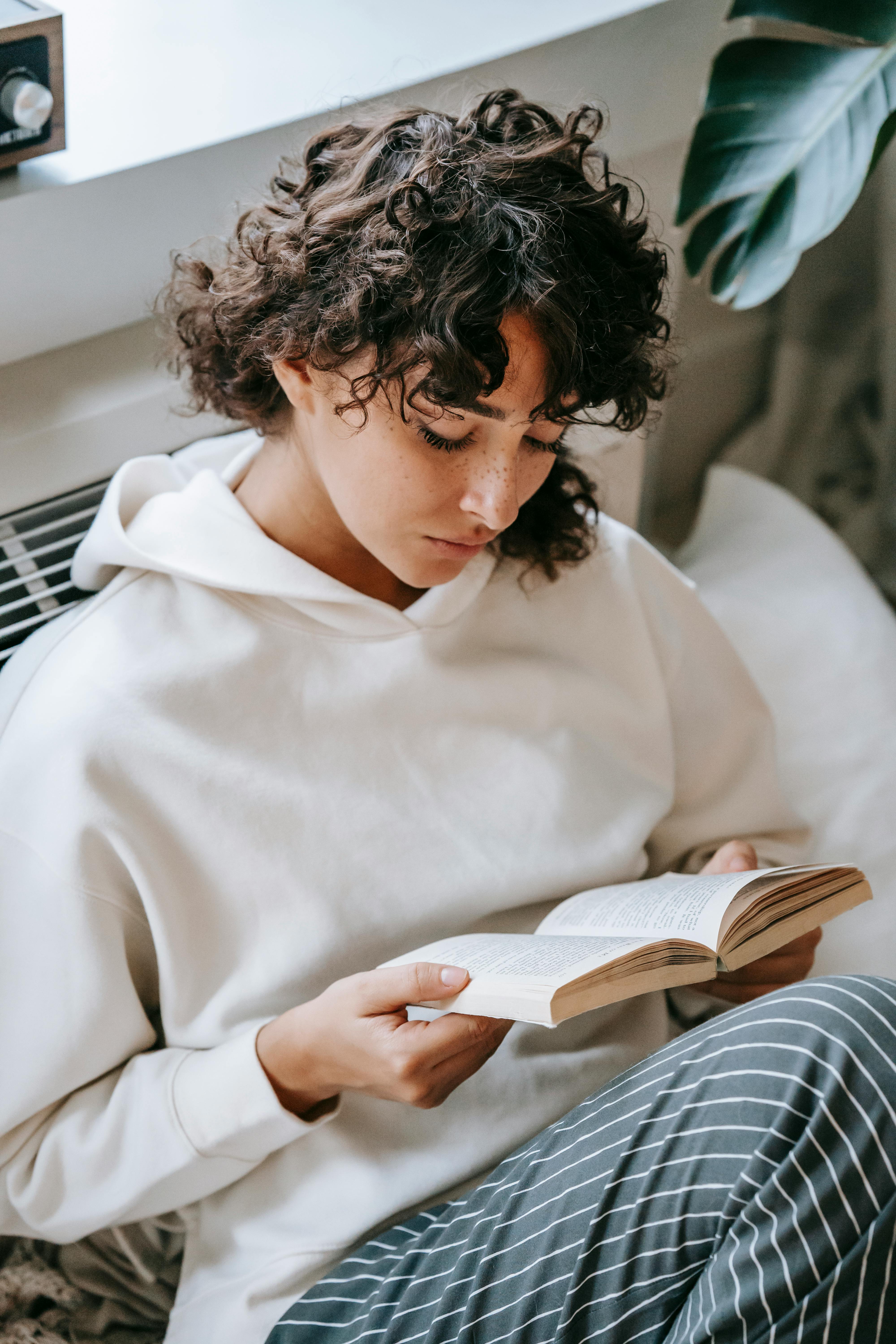 pensive woman reading book in living room