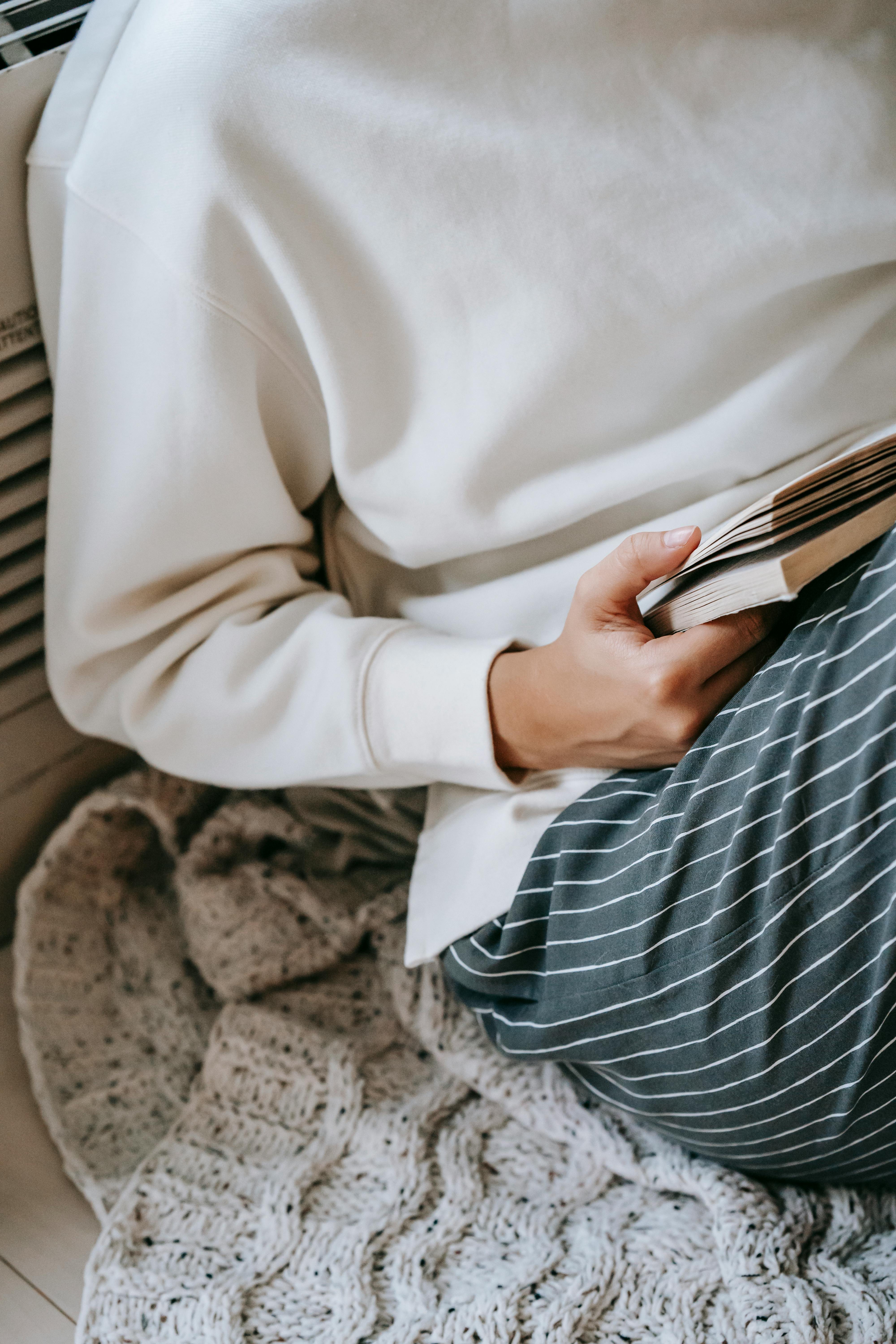 woman in striped trousers reading book