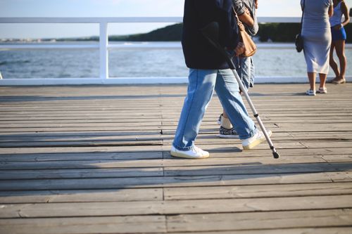 Free A group enjoying a leisurely walk on a sunny beach pier during summer. Stock Photo