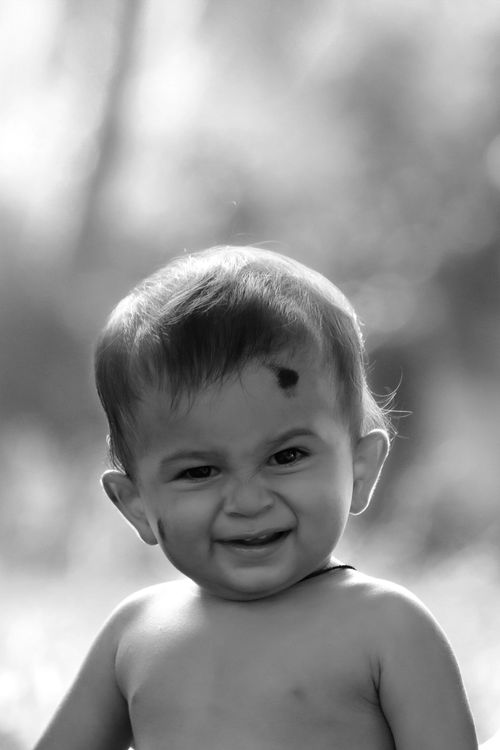 Free Close-up portrait of a smiling baby in a black and white photo, showcasing innocence and joy. Stock Photo