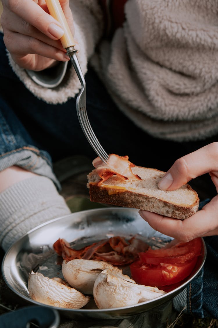 Person Holding A Fork And Bread