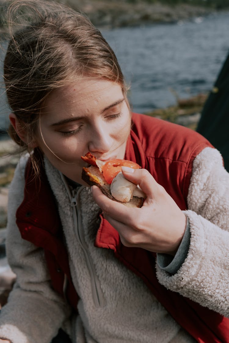 Woman In Jacket Eating A Bread