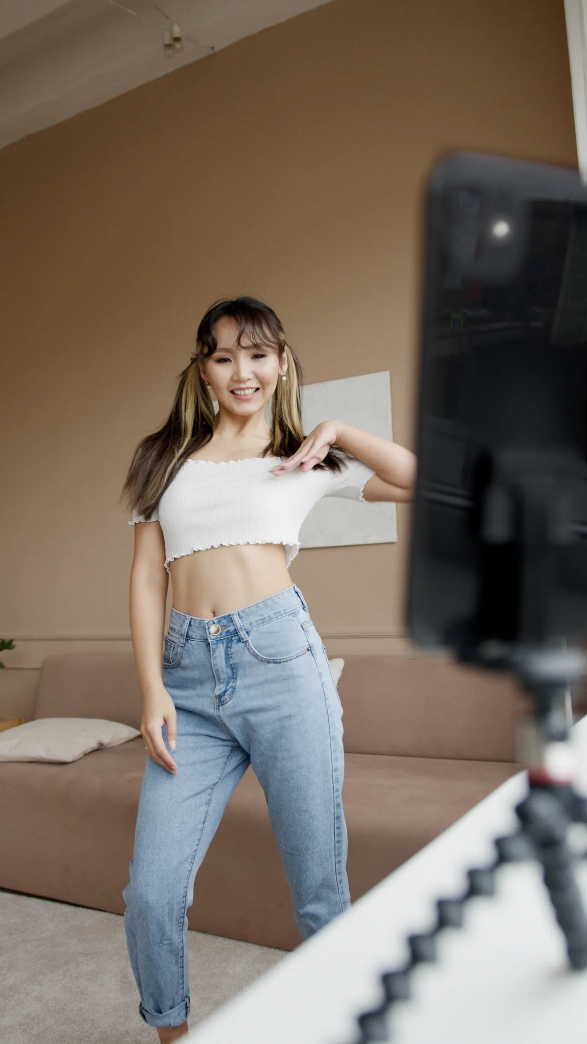 Ilustrasi creator wanita merekam gerakan dance simpel dengan tripod smartphone