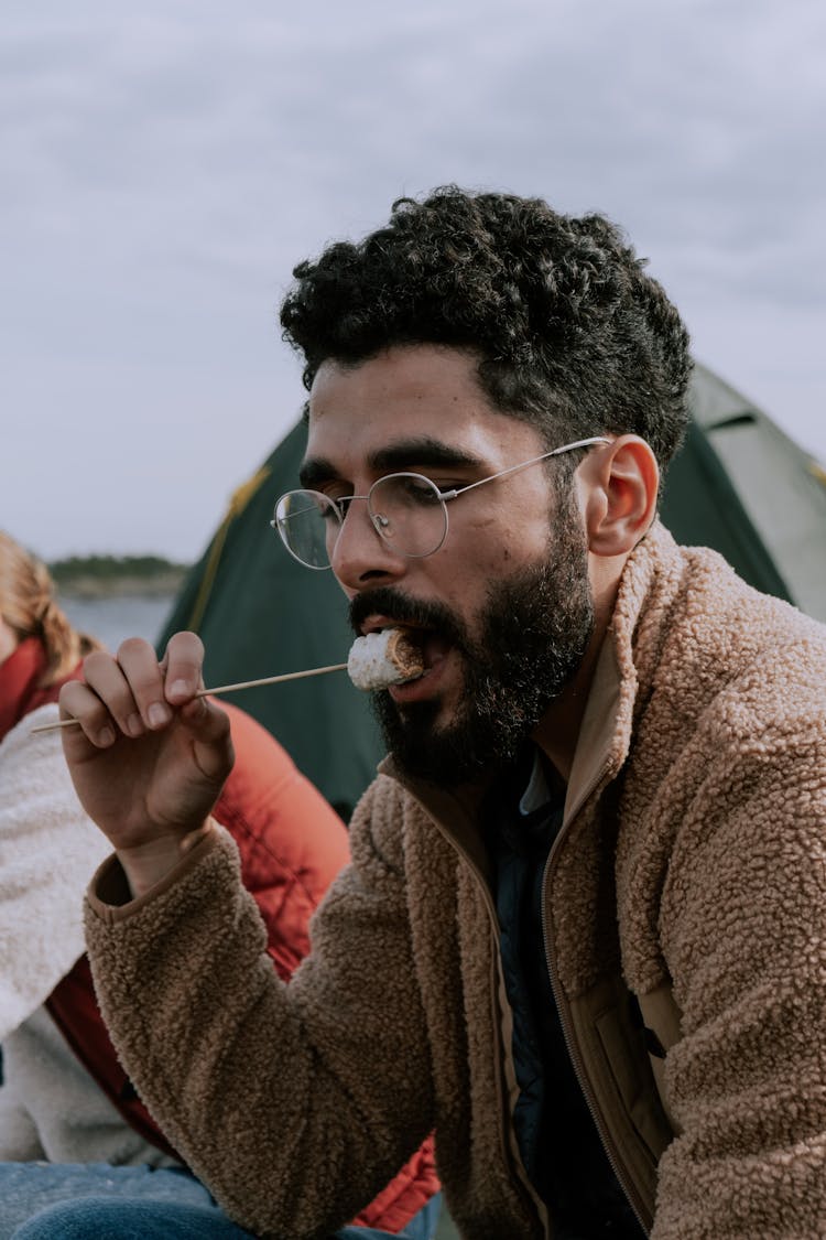 Man In Brown Sweater Food On A Skewer