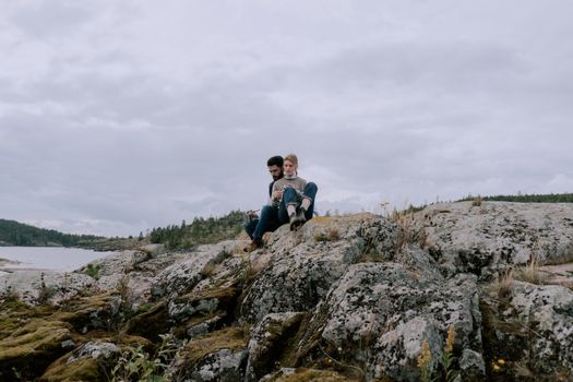 Woman in Blue Jacket Sitting on Rock Formation