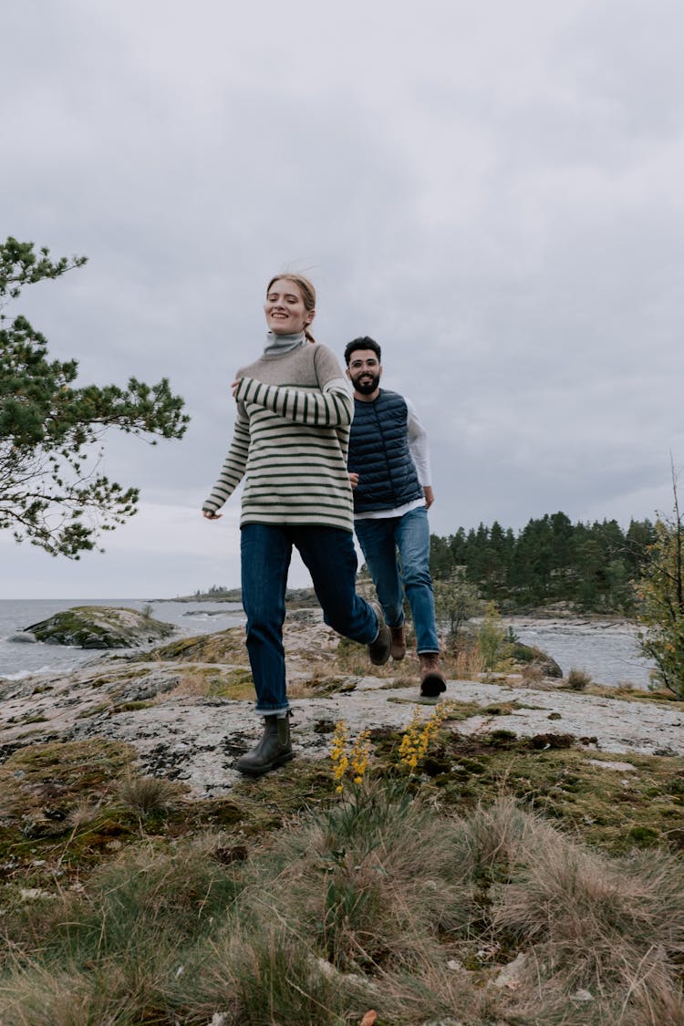 Man Chasing Woman On A Rocky Field