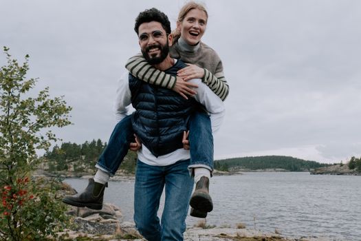 Man in Gray and Black Striped Sweater Hugging Woman in Gray Jacket