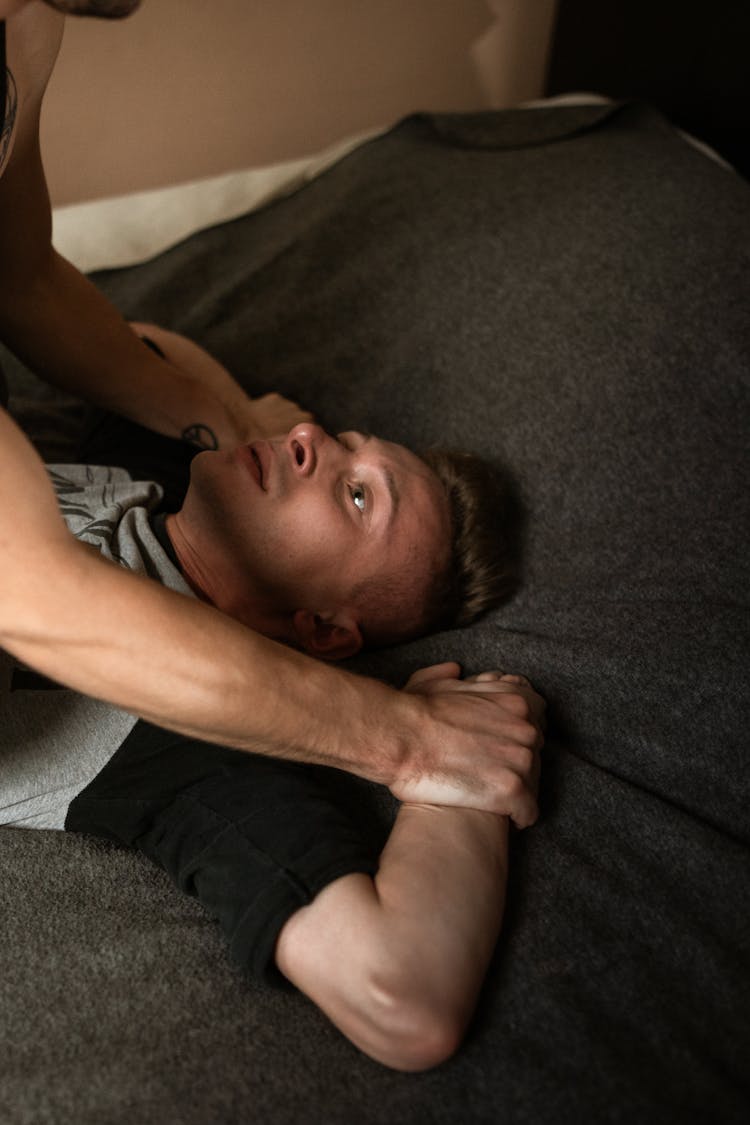 Boy In Gray Shirt Lying On Bed