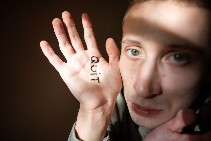 Person zeigt Quit auf der Hand