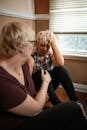 Two Women Sharing Emotional Moment while Sitting on the Floor