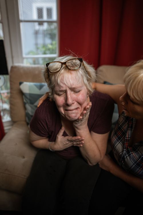 Free A woman in distress is being comforted on a sofa, showing emotional support and empathy. Stock Photo
