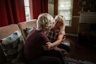 Two Women Sharing Emotional Moment while Sitting on a Sofa