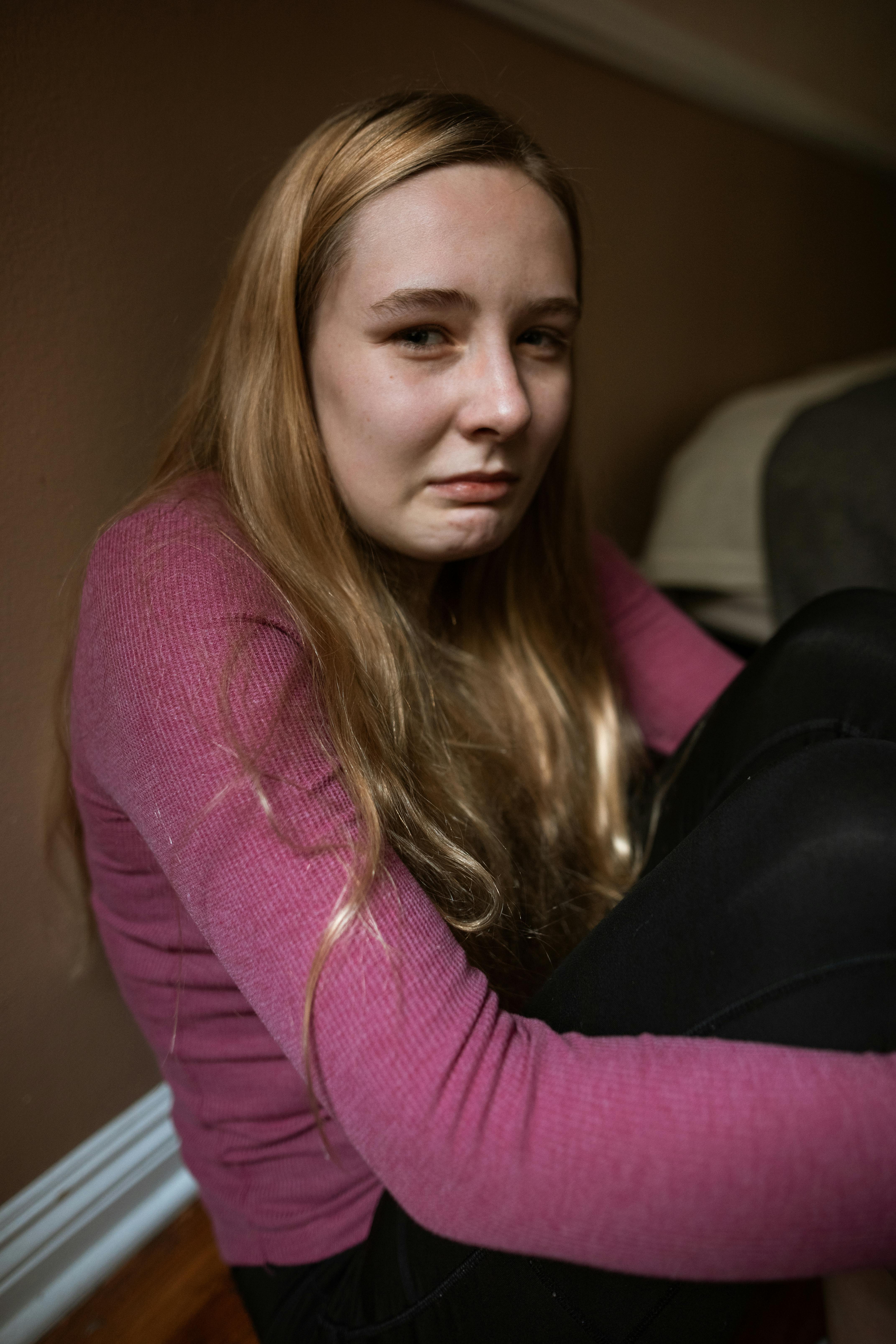 scared woman in pink long sleeve shirt