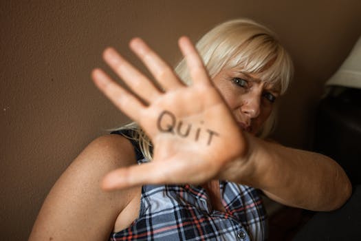 A powerful portrayal of a woman displaying 'Quit' on her palm, emphasizing resilience and advocacy.